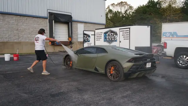 Lamborghini Huracán getting a pre-rinse beside the Next Level Detailing trailer